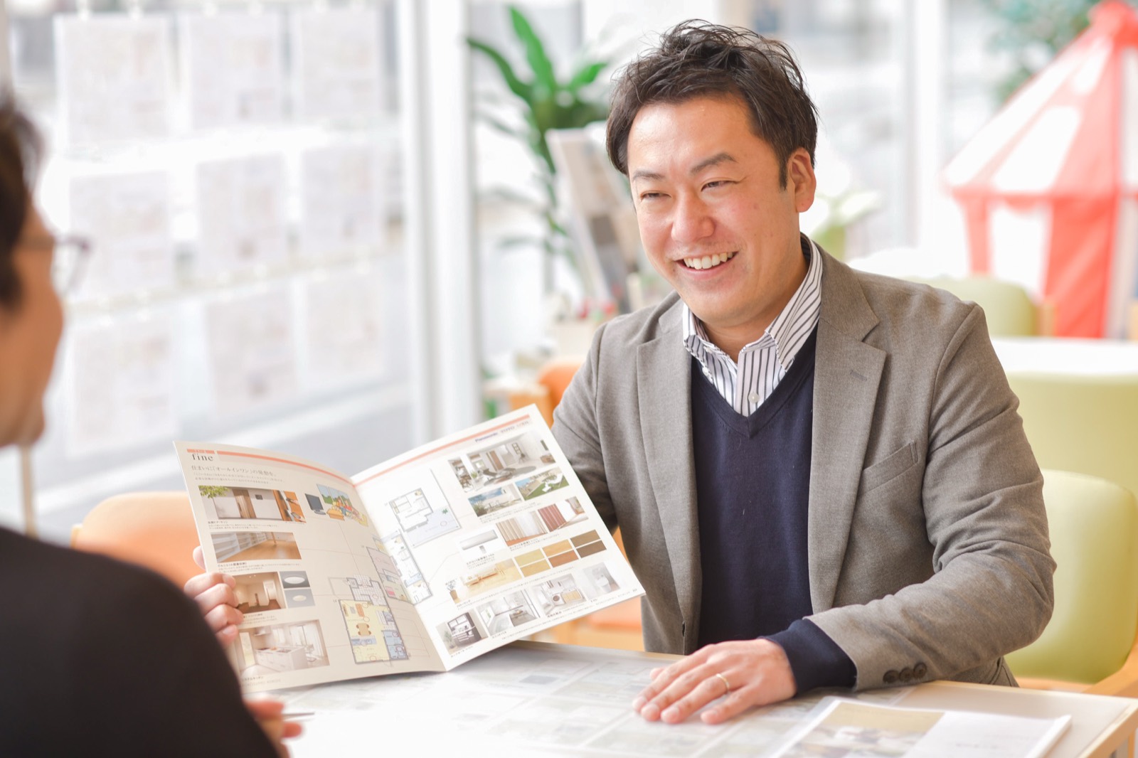 住宅カタログを手にお客様へ提案するBK不動産のご担当者